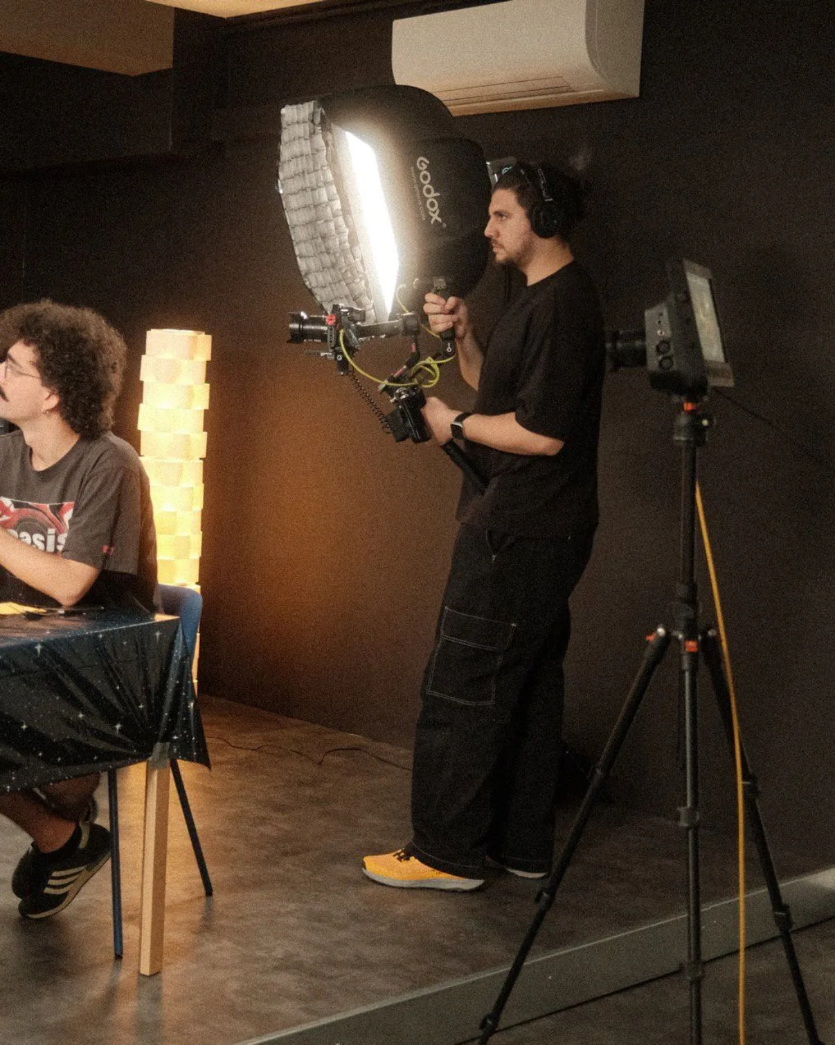Operatore con gimbal e softbox Godox sul set
