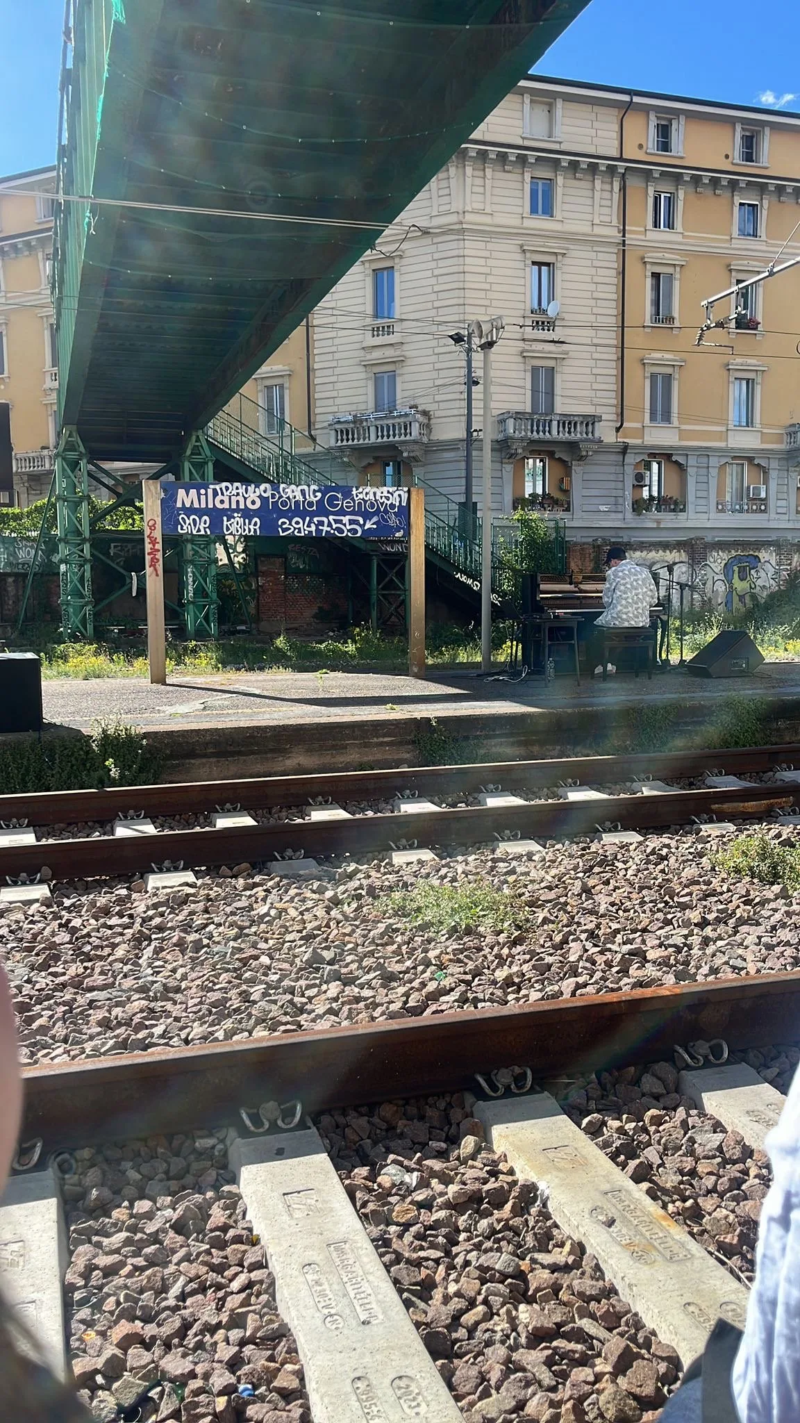 Pianista che suona accanto ai binari di Porta Genova
